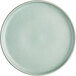 A round, matte, light blue plate with a smooth surface and slightly raised rim.