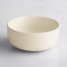A plain, round, off-white bowl with a matte finish on a light surface.