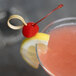 A cocktail with a Regal Maraschino cherry and a lemon slice on the rim.