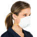 A woman wearing a Cordova N-95 particulate respirator with yellow straps.