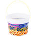 A white plastic bucket filled with mini donuts with a yellow handle.