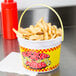 A 48 oz. plastic French fry bucket with a handle filled with French fries.