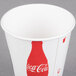 A white paper Solo cold cup with a red and white Coca Cola logo.