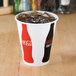 A Solo paper cup with a Coke and ice in it.