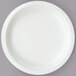 A Creative Converting white paper plate on a gray surface.