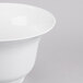 A white Tablecraft cast aluminum tulip salad bowl on a gray surface.