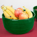A Tablecraft green cast aluminum bowl filled with bananas and apples.