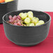 A Tablecraft natural cast aluminum fruit bowl filled with grapes on a table.
