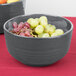 A Tablecraft gray cast aluminum fruit bowl filled with grapes.