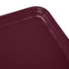 A close up of a burgundy rectangular Cambro Camtray.