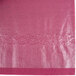 A close up of a burgundy tissue / poly table cover with a white background.
