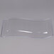 A clear plastic Fineline disposable plate with a curved edge.