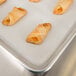 A Baker's Mark parchment paper sheet with a tray of pastries on a white surface.