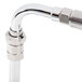 A T&S chrome wall mount pet grooming faucet with a hose attached to a metal pipe.