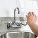 A person using an Eagle Group hand sink with a gooseneck faucet.