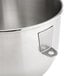 A close up of a stainless steel KitchenAid mixing bowl with a metal handle.