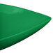 A close up of a green Tablecraft cast aluminum triangle display bowl.