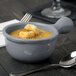 A gray cast aluminum Tablecraft soup bowl with a handle filled with soup and croutons.
