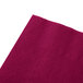A close up of a Hoffmaster burgundy beverage napkin with a small pattern.