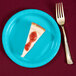 A piece of cheesecake on a Bermuda blue paper plate with a fork.