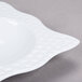 A white square melamine bowl with a pattern on it.