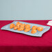 A gray Tablecraft rectangular platter with croissants on it.