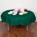 A table with a Hunter Green Creative Converting tablecloth, plates, and cups.