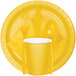 A school bus yellow paper plate with a fork, spoon, and cup on it.