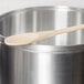 A Thunder Group 18" wooden spoon in a silver pot.