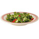A white melamine bowl filled with salad with strawberries and garlic.