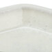 A white trapezoid Cambro tray with silver specks on the rim.