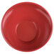A close-up of a cranberry red Elite Global Solutions slanted melamine bowl.