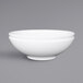 A close-up of a white Elite Global Solutions Sunburst melamine bowl with a white rim.