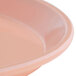 A pink round Cambro fiberglass tray with a rim.