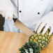 A person in a white glove cutting a pineapple with a Dexter-Russell V-Lo Chef Knife.