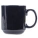 A white mug with a dark blue handle.