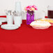 A Creative Converting Classic Red table cover on a table with plates and cups.