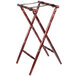 A Tablecraft mahogany wood tray stand with a spindle design and strap.