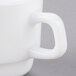 A close-up of a white Arcoroc coffee cup with a handle.