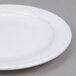 An Arcoroc white narrow rim plate on a gray surface.