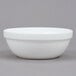 An Arcoroc white glass bowl with a white rim on a gray background.
