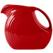 A red Fiesta pitcher with a handle.