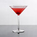 A Thunder Group plastic martini glass with red liquid on a table.