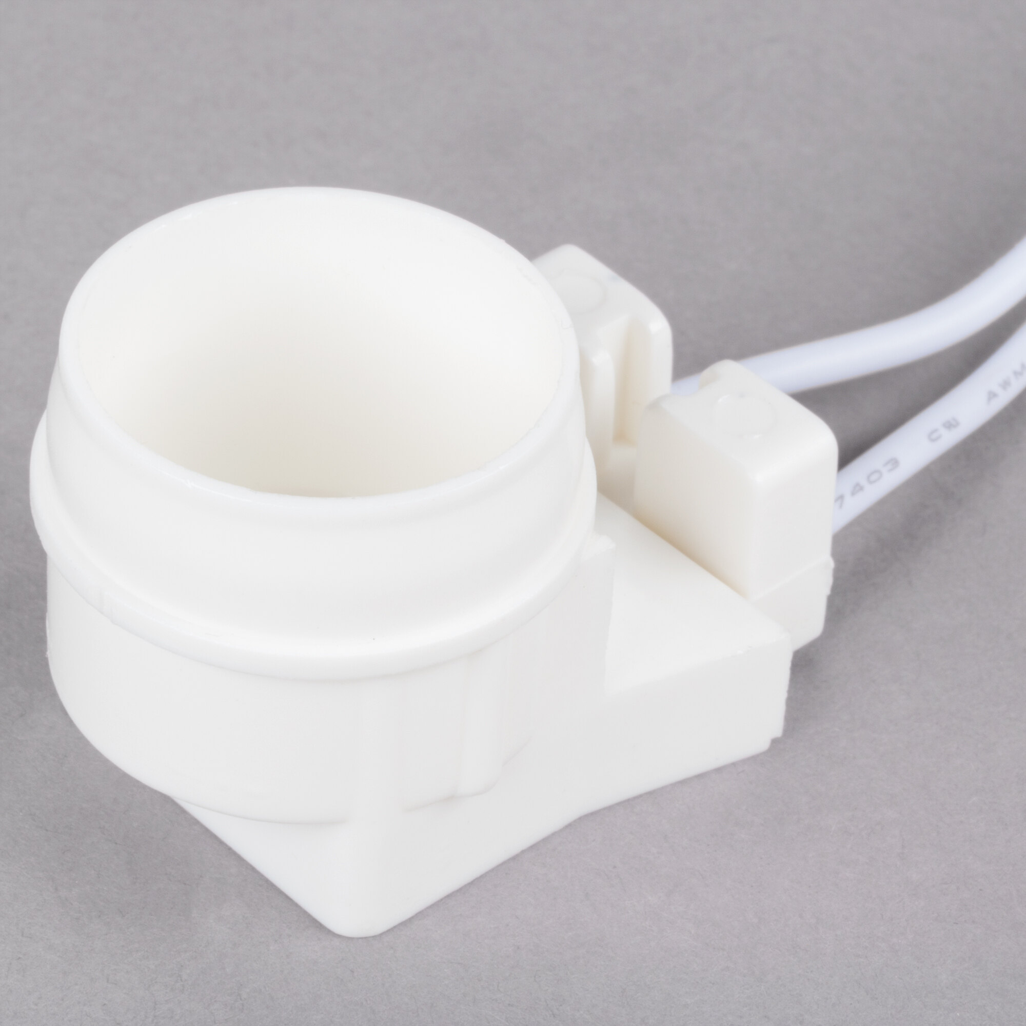 An Avantco fluorescent light socket assembly with a white plastic object and a wire