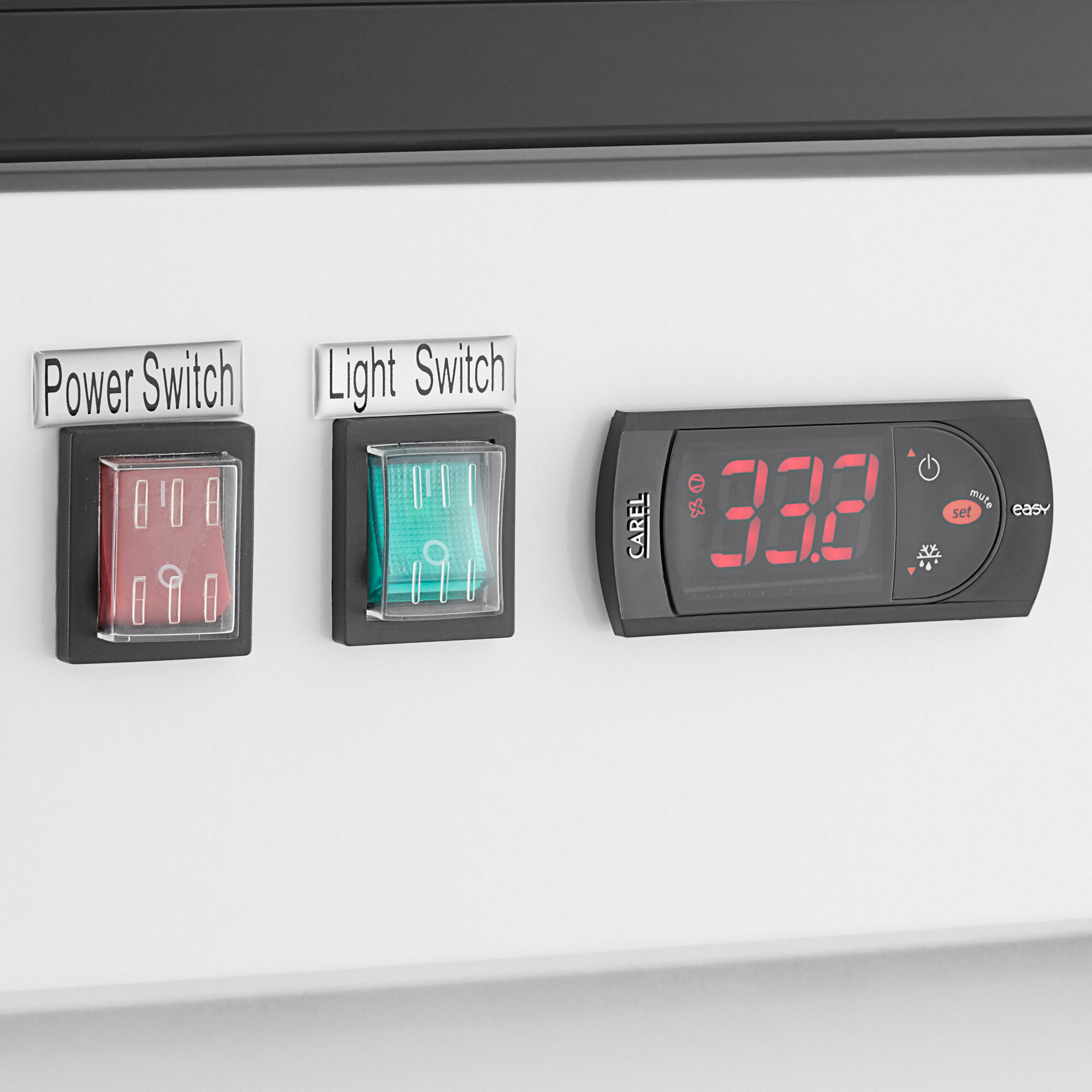 A control panel with a power switch, light switch, and digital temperature display for a glass door merchandiser refrigerator.