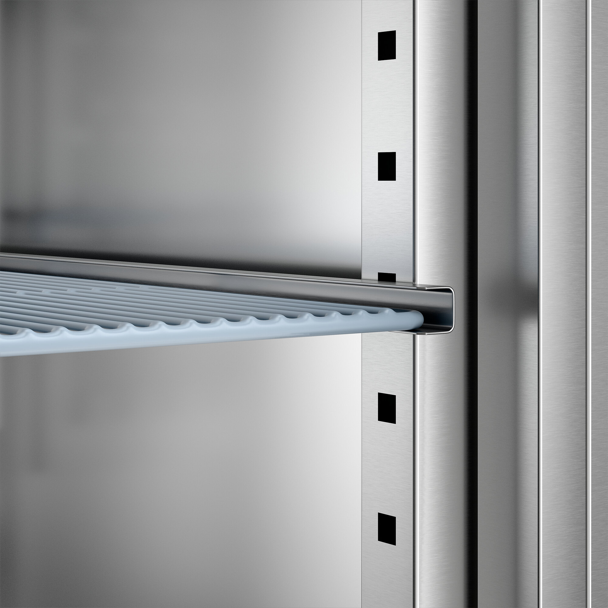 A close-up view of an adjustable wire shelf inside a stainless steel reach-in freezer.