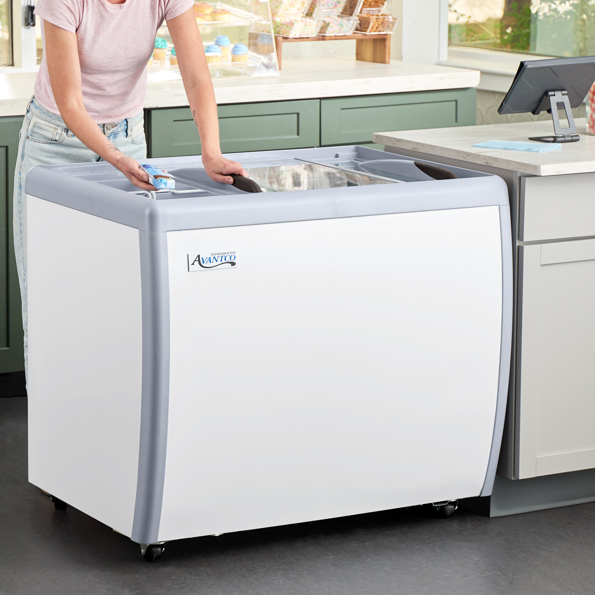 A white Avantco flat top display ice cream freezer with a glass sliding lid.