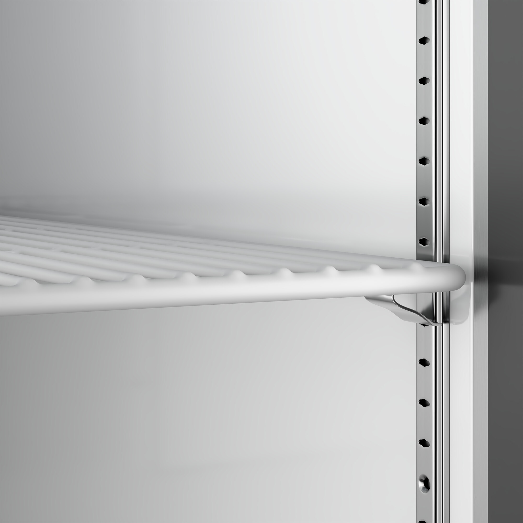 A close-up view of an adjustable wire shelf inside a stainless steel reach-in refrigerator.
