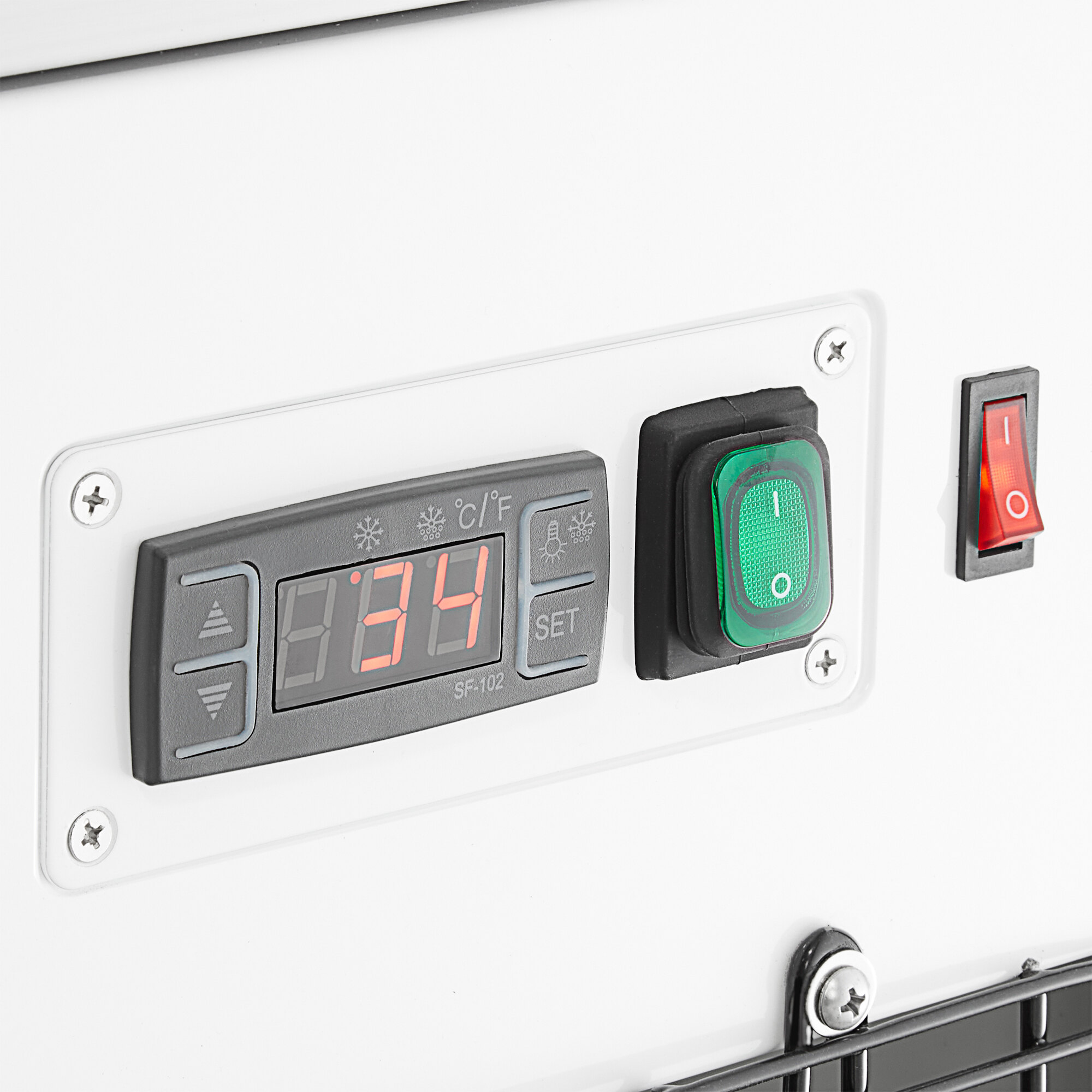 A control panel with a digital temperature display, green power switch, and red rocker switch on a refrigerated bakery display case.