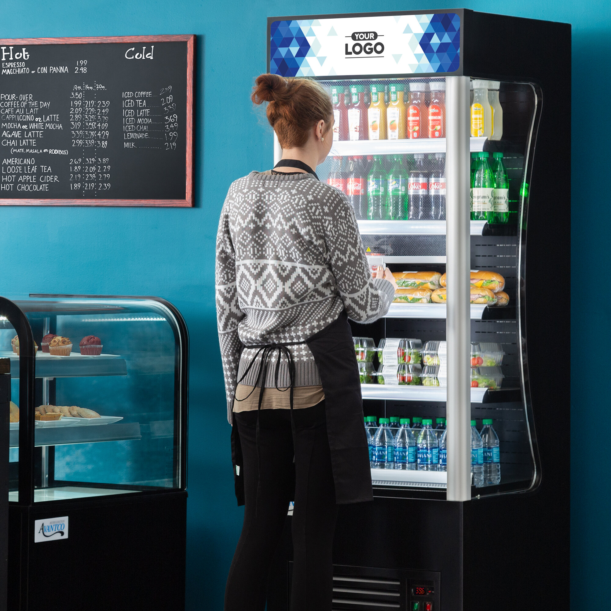 A woman standing in front of a refrigerated air curtain merchandiser with customizable panel.